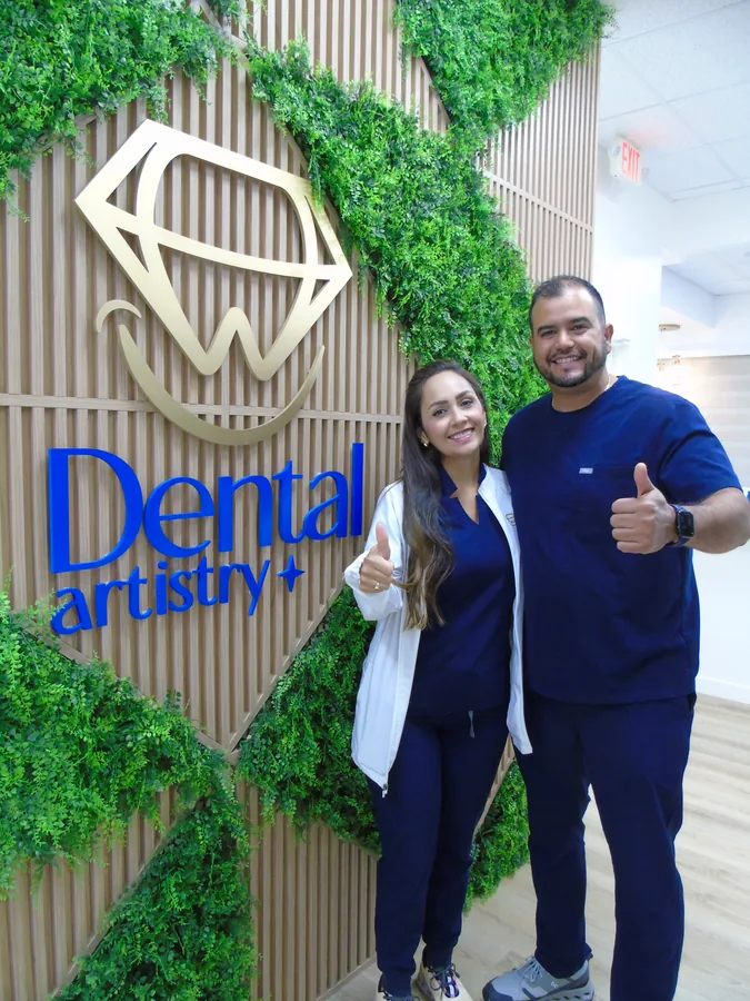 Equipo de Dental Artistry frente al mural con el logo de la clínica